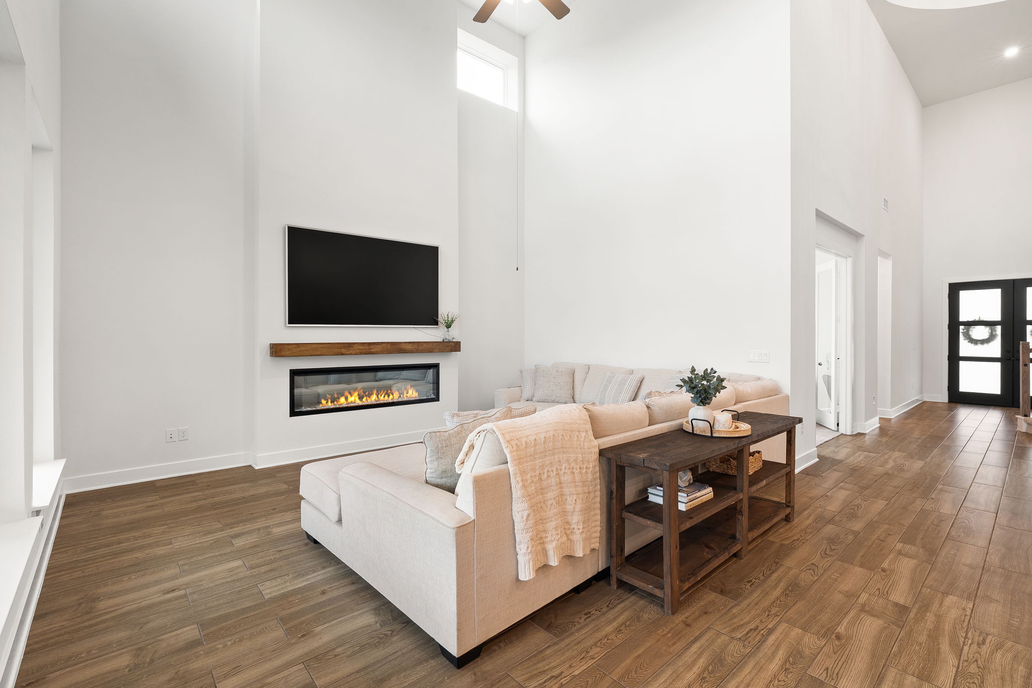 515 Watershield Cove Georgetown, TX 78633 - Photo 11 of 40 A spacious living room welcomes with soaring ceilings, rich wood flooring, and a modern linear fireplace.