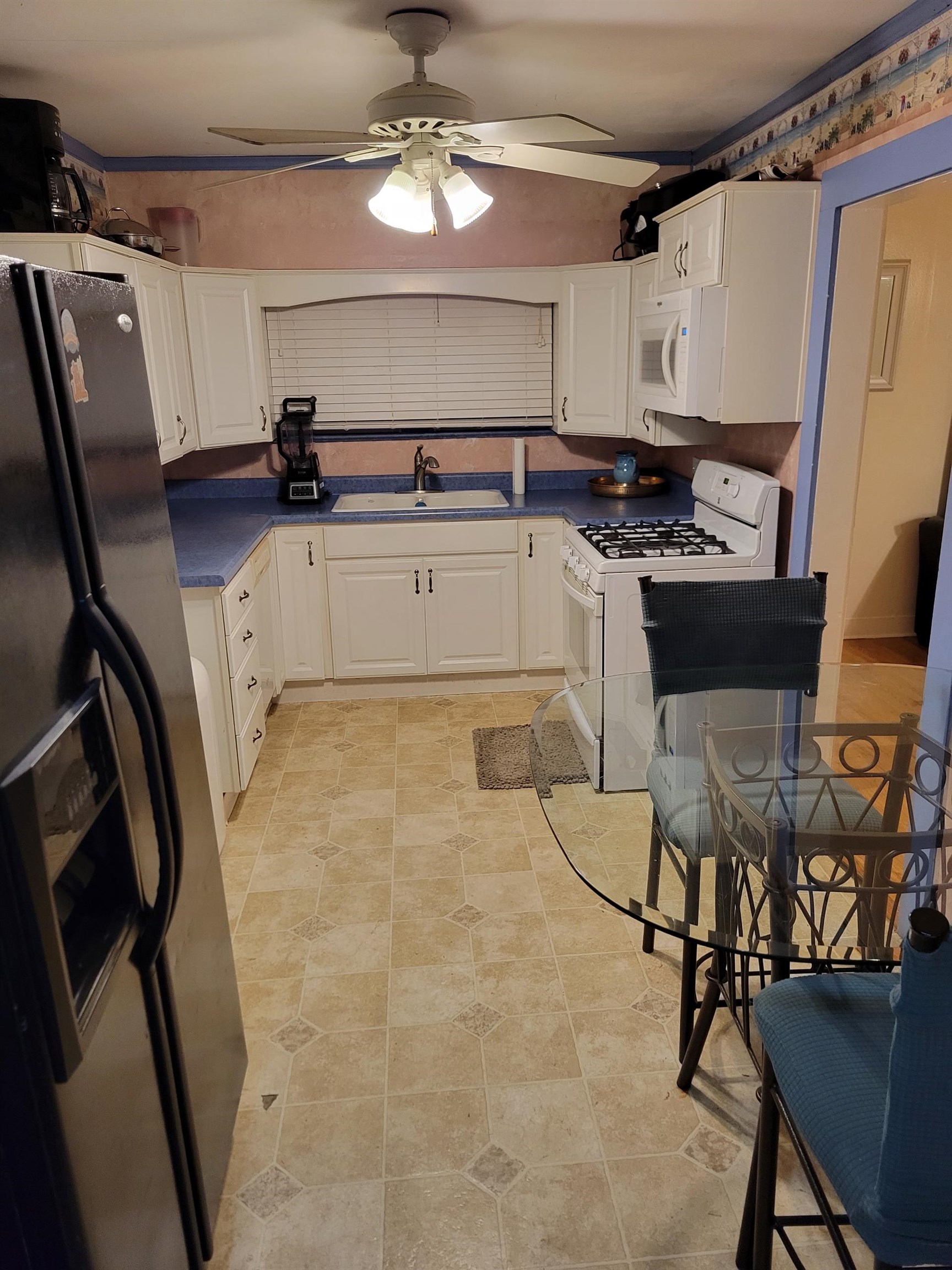 3580 Allandale Lane Memphis, TN 38111 - Photo 3 of 11 a kitchen with stainless steel appliances a stove a refrigerator a sink a dining table and chairs with wooden floor