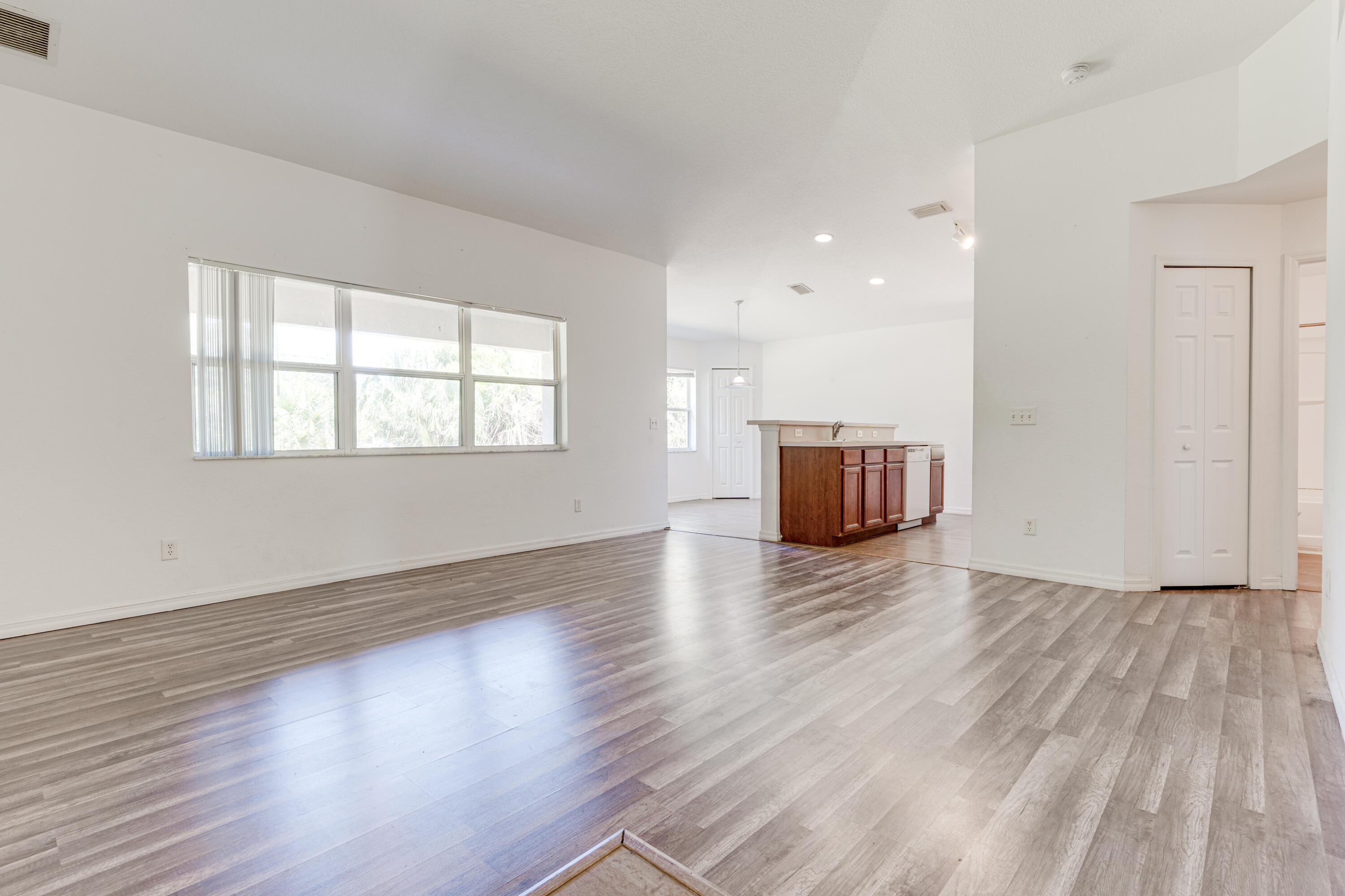 500 Topeka Road Southwest Palm Bay, FL 32908 - Photo 4 of 12 an empty room with wooden floor and windows