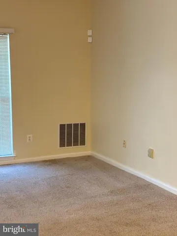 a view of wooden floor and chandelier fan in a room