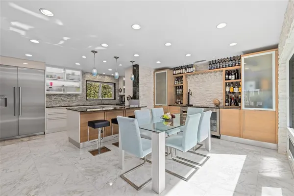 a kitchen with a refrigerator and chairs