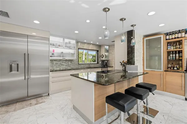 a kitchen with stainless steel appliances granite countertop a sink and a refrigerator