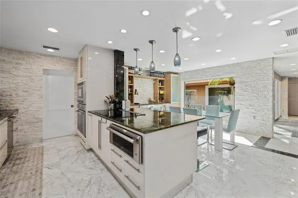 a kitchen with stainless steel appliances kitchen island granite countertop a sink and cabinets