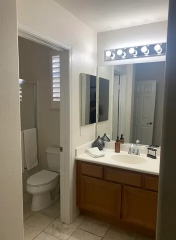 a bathroom with a double vanity sink toilet and mirror