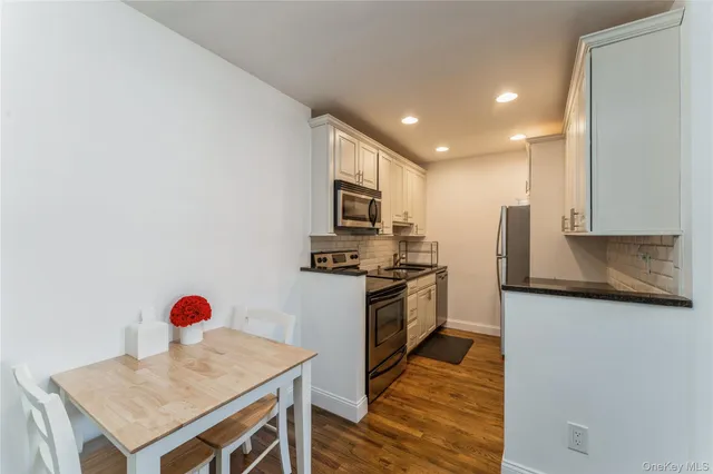 a kitchen with stainless steel appliances granite countertop a stove microwave and refrigerator