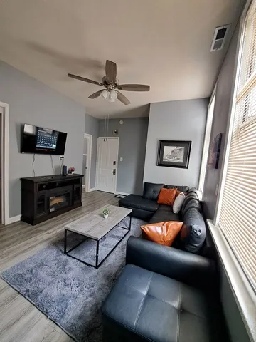 a living room with furniture and a wooden floor