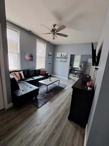 a living room with furniture and a wooden floor