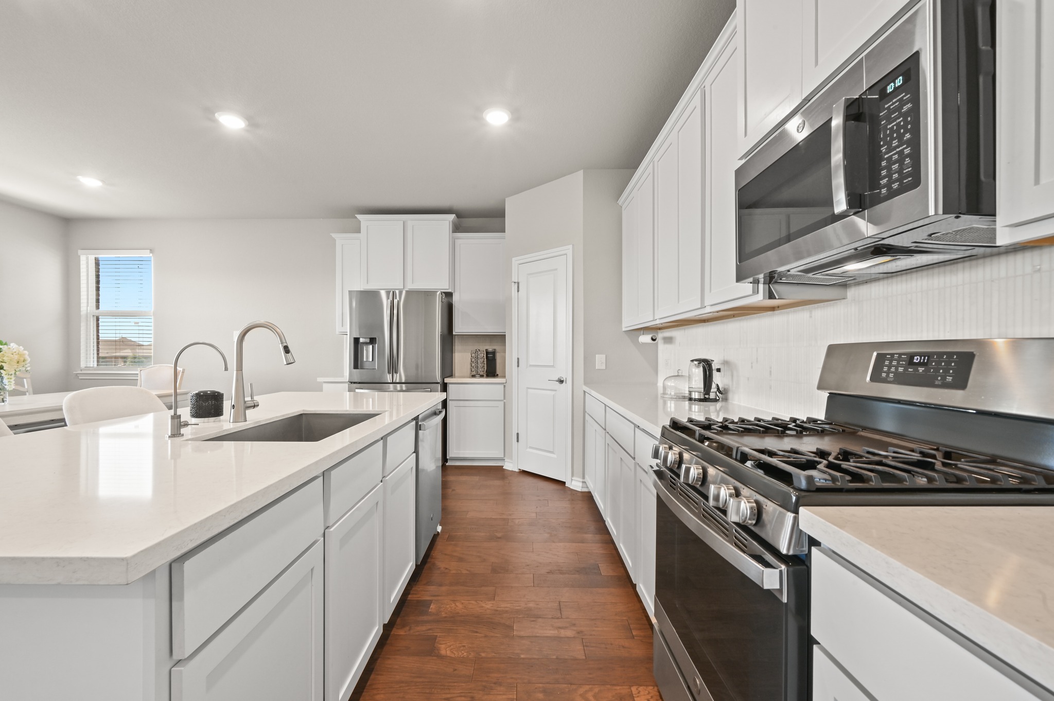 488 Pepperbark Loop Buda, TX 78610 - Photo 13 of 31 A well-appointed culinary space featuring sleek cabinetry, quartz countertops, and modern stainless steel appliances.