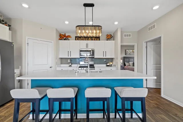 a kitchen with a dining table chairs and white cabinets