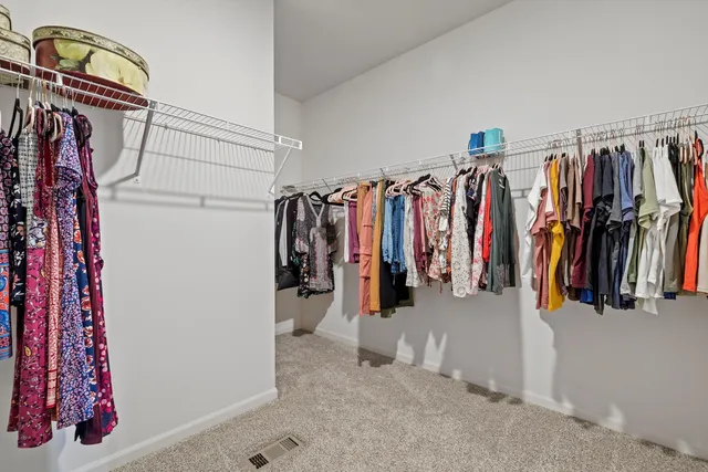 a view of walk in closet with clothes