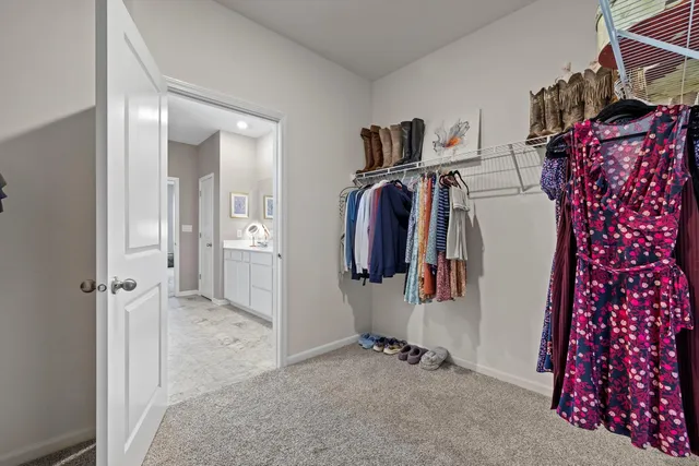 a view of walk in closet with clothes and shoes