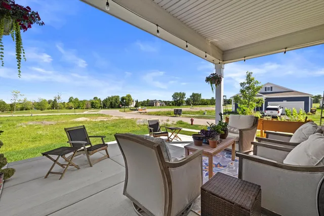 a view of a patio with table and chairs potted plants and floor to ceiling window and potted plants