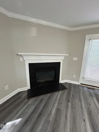an empty room with wooden floor and a fireplace