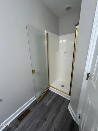 an empty room with wooden floor and entrance