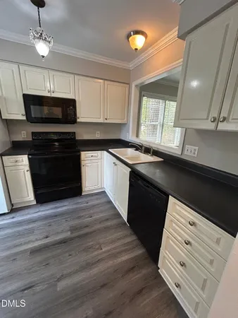 a kitchen with stainless steel appliances granite countertop a sink a stove and a refrigerator