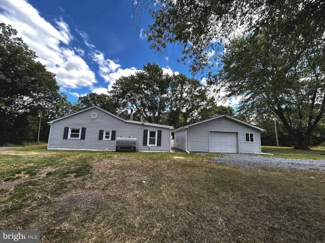 a white house that has a tree in front of it