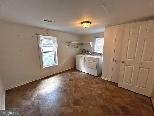 an empty room with windows & cabinet