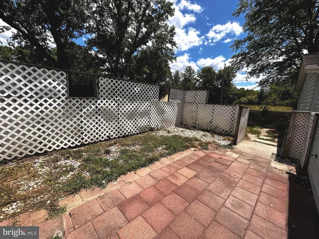 a view of backyard with wooden fence