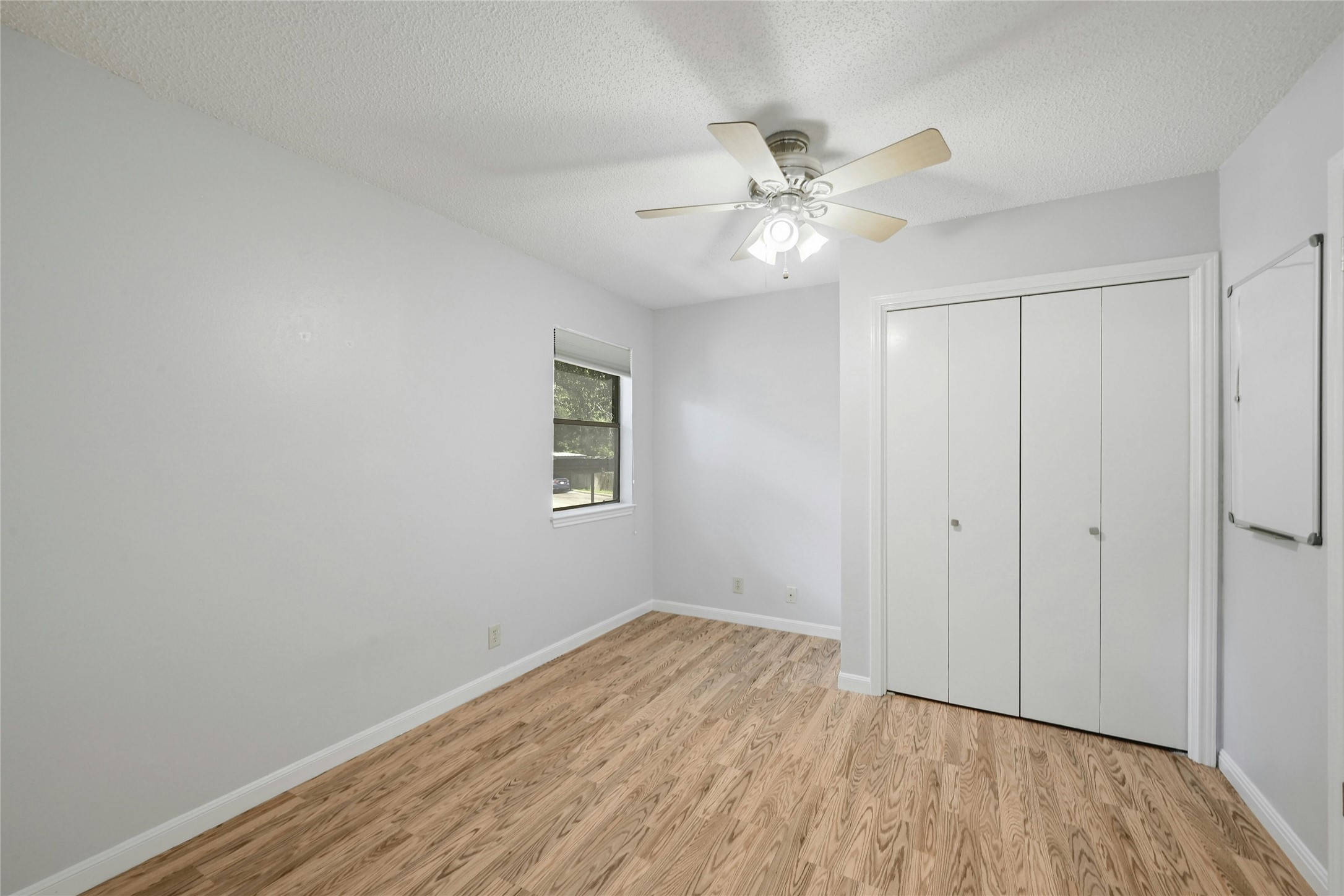 9226 Jollyville Road, Unit 221 Austin, TX 78759 - Photo 13 of 20 A quiet bedroom showcases durable wood flooring and a refreshing ceiling fan for comfortable living.