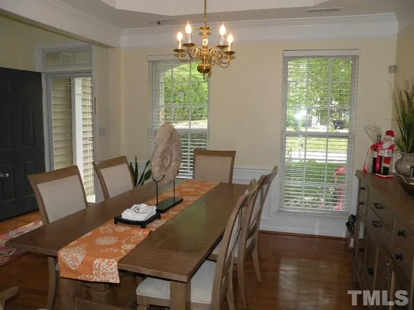 a view of a dining room with furniture a chandelier and wooden floor