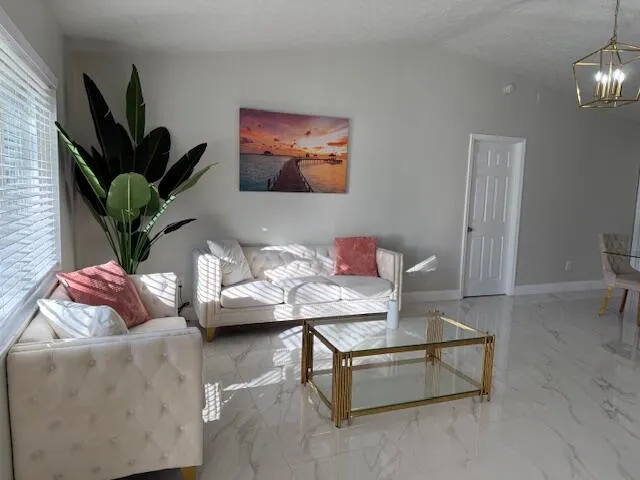 a living room with furniture potted plant and a flat screen tv