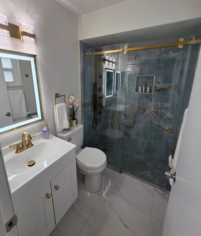 a bathroom with a sink a toilet and shower