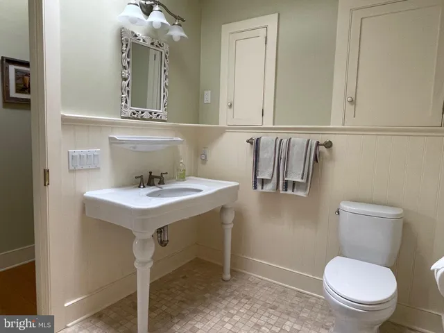 a bathroom with a toilet a sink and mirror