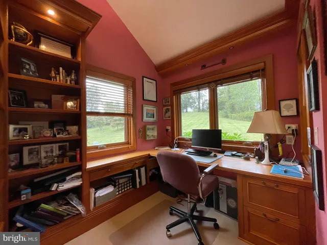a view of a workspace with furniture and a window