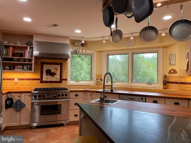 a kitchen with stainless steel appliances a stove a sink and a microwave