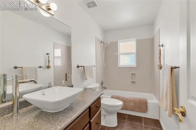 a bathroom with a granite countertop sink a toilet a mirror and shower