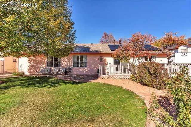 a front view of a house with a garden and trees