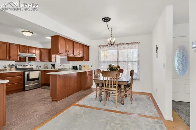 a kitchen with a dining table chairs and refrigerator