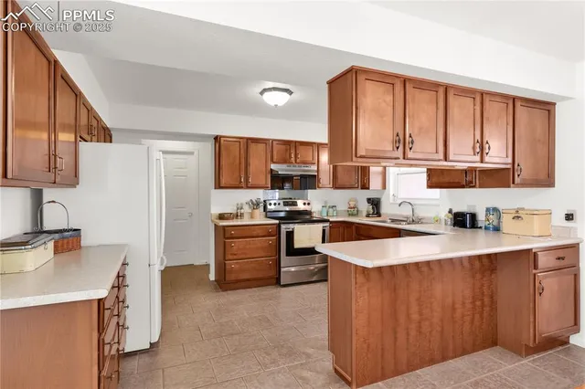 a large kitchen with stainless steel appliances granite countertop a sink dishwasher stove and refrigerator