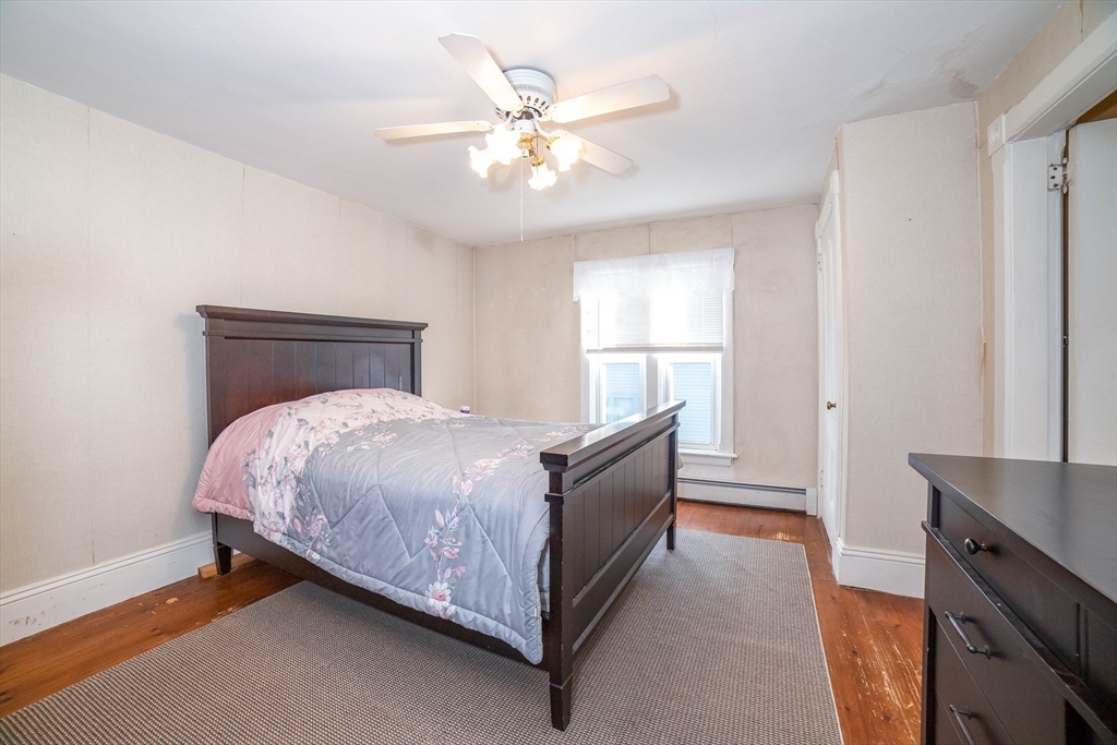 145 Center Road Dudley, MA 01571 - Photo 15 of 32 a bed room with a bed and a chandelier