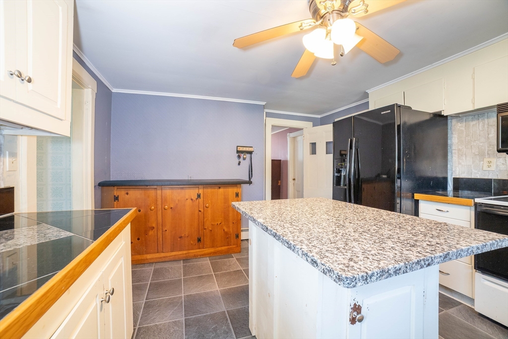 145 Center Road Dudley, MA 01571 - Photo 7 of 32 a kitchen with kitchen island granite countertop a sink and a refrigerator