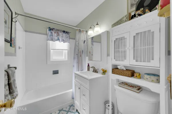 a bathroom with a tub sink vanity granite and shower