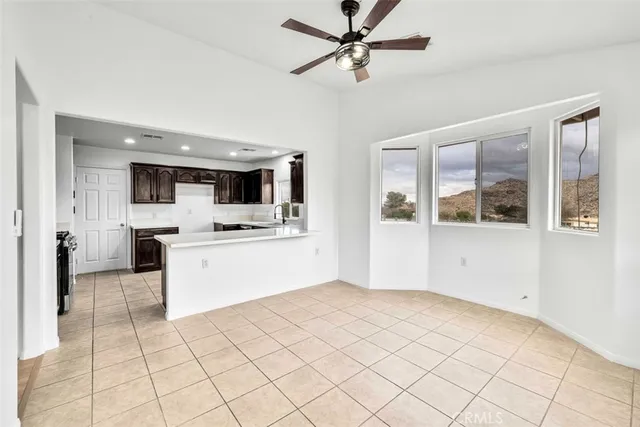 a view of kitchen with stainless steel appliances kitchen island white cabinets and a fireplace