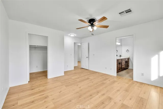 a view of a big room with wooden floor and a chandelier fan