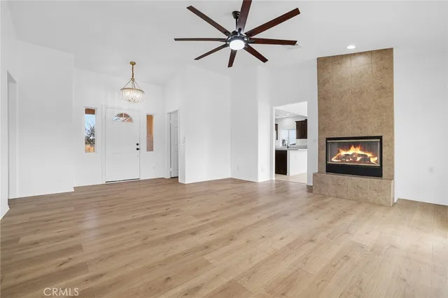 a view of empty room with a fireplace and wooden floor