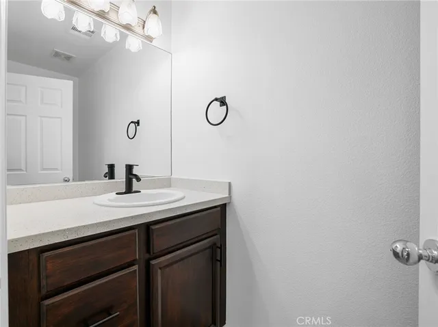 a bathroom with a sink a light fixture and a mirror