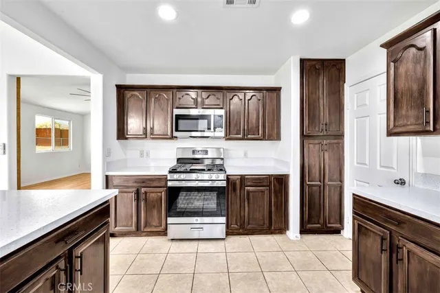 a kitchen with stainless steel appliances granite countertop a stove microwave and sink