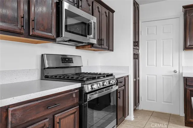 a kitchen with stainless steel appliances granite countertop white cabinets and a stove top oven