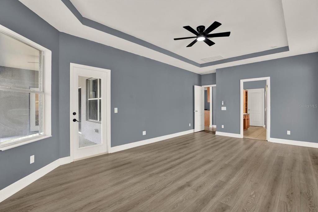 13397 Hunters Point Street Spring Hill, FL 34609 - Photo 15 of 38 a view of an empty room with wooden floor and a ceiling fan