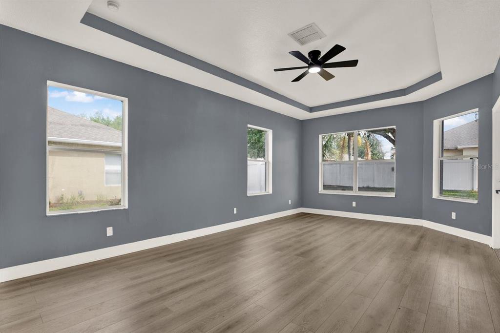 13397 Hunters Point Street Spring Hill, FL 34609 - Photo 16 of 38 a view of an empty room with a window and wooden floor