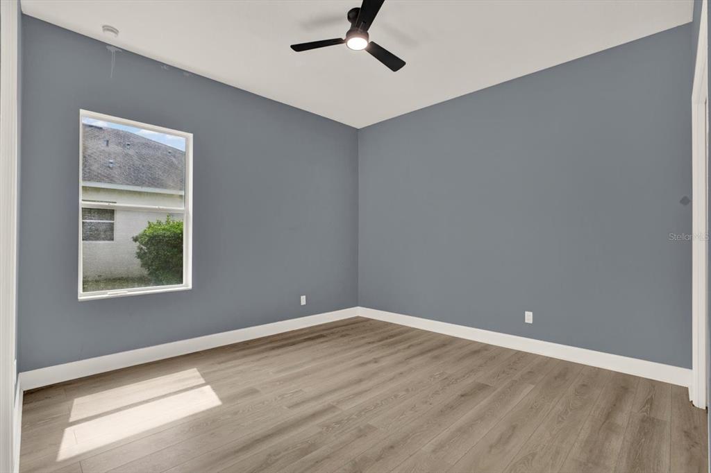 13397 Hunters Point Street Spring Hill, FL 34609 - Photo 19 of 38 a view of an empty room with wooden floor and a window