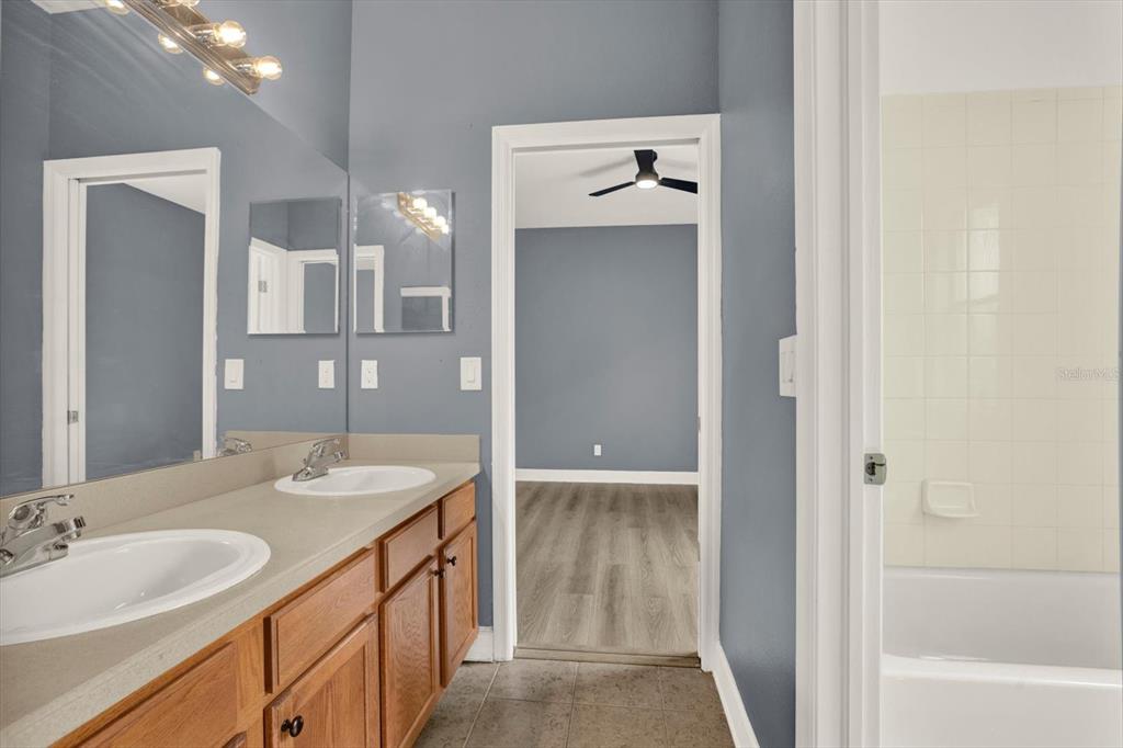 13397 Hunters Point Street Spring Hill, FL 34609 - Photo 23 of 38 a bathroom with a double vanity sink mirror and bathtub