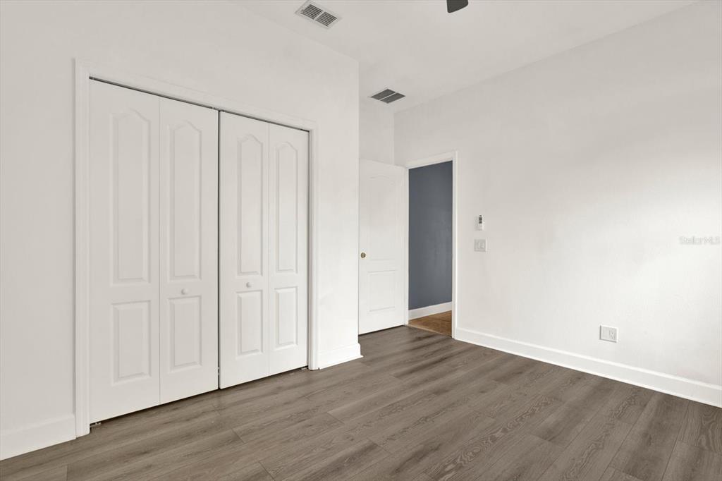 13397 Hunters Point Street Spring Hill, FL 34609 - Photo 24 of 38 a view of an empty room with wooden floor