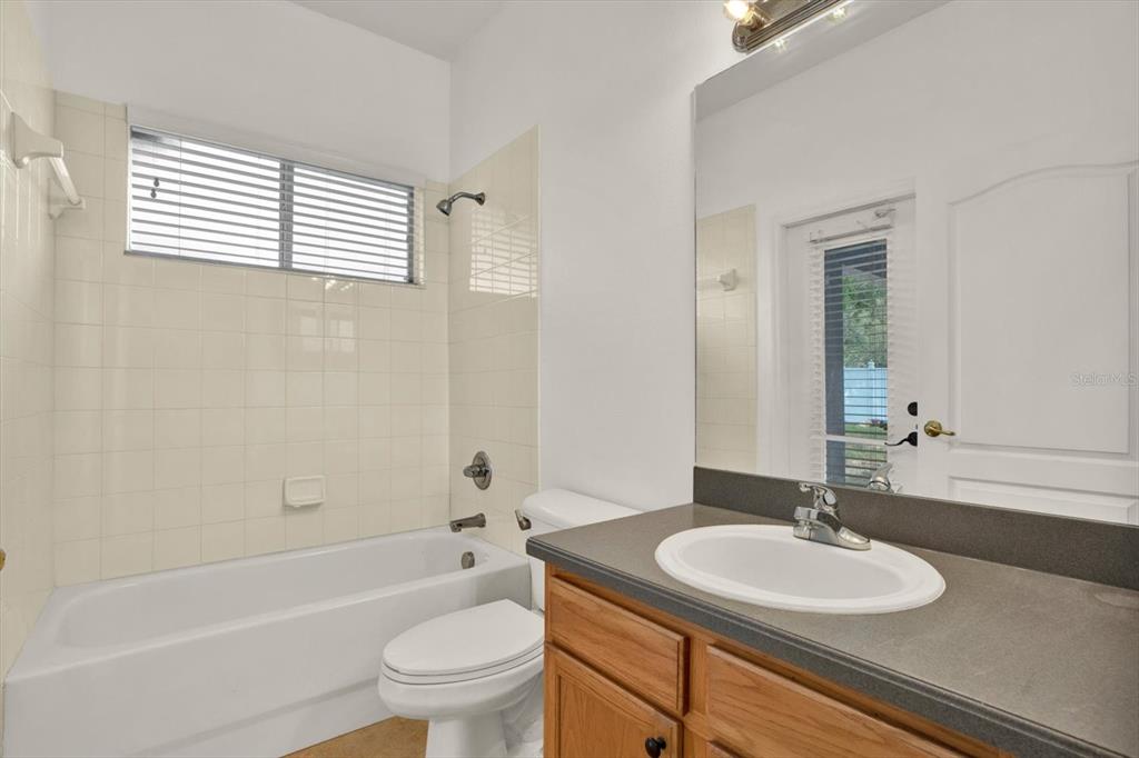 13397 Hunters Point Street Spring Hill, FL 34609 - Photo 25 of 38 a bathroom with a sink toilet a mirror and bathtub