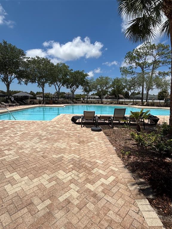 13397 Hunters Point Street Spring Hill, FL 34609 - Photo 37 of 38 a view of a swimming pool with a table and chairs