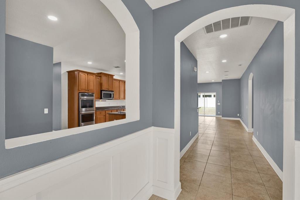 13397 Hunters Point Street Spring Hill, FL 34609 - Photo 5 of 38 a view of a hallway with wooden floor and windows